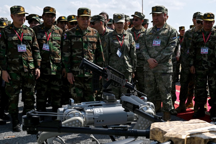 Des représentants chinois et cambodgiens devant un chien-robot militaire, en mai 2024 ( AFP / TANG CHHIN SOTHY )