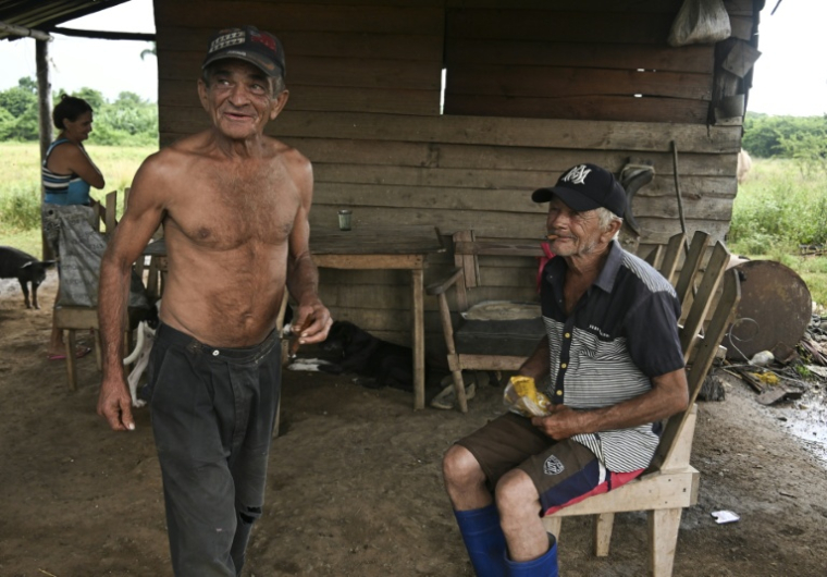 Fidel Maqueira (à gauche) se tient aux côtés de Victorino Maqueira devant leur maison à Consolacion del Sur, à Cuba, le 26 juillet 2026 ( AFP / YAMIL LAGE )