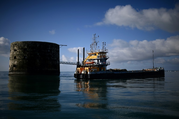 Une barge effectue des travaux de terrassement à proximité du Fort Boyard qui menace de s'écrouler, au large de l'île d'Aix dans l'océan Atlantique, le 16 juillet 2025 en Charente-Maritime ( AFP / Christophe ARCHAMBAULT )