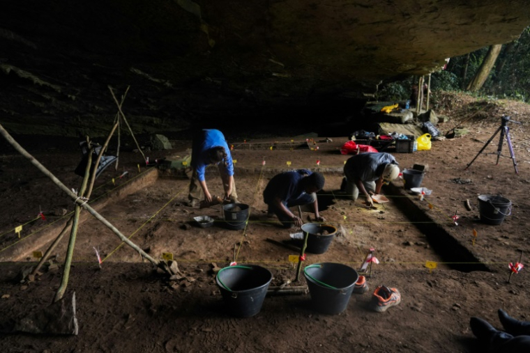 Des étudiants en archéologie participent à des fouilles à l'intérieur de la grotte de Youmbidi à Lastourville (Gabon), le 27 juin 2025. ( AFP / Nao Mukadi )