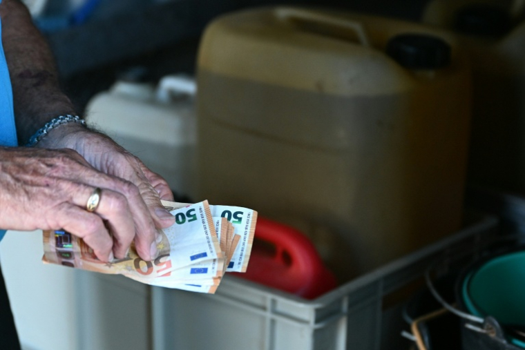 Un conducteur paye en cash dans une station service au Pas-de-la-Case, en Andorre, le 15 septembre 2026 ( AFP / Matthieu RONDEL )
