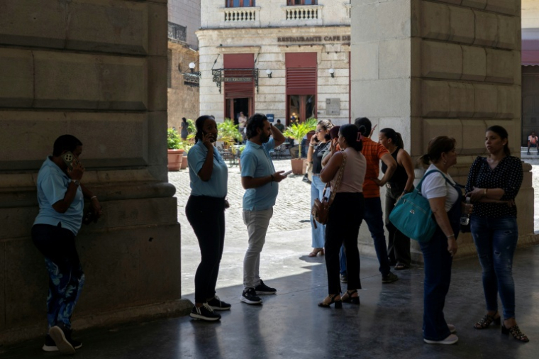 Des employés attendent à l'extérieur d'un bâtiment après des secousses provoquées par un séisme de magnitude 6,5 à La Havane, le 8 juin 2026 à Cuba ( AFP / Pablo PORCIUNCULA )