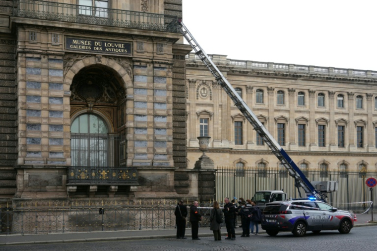 Des policiers français se tiennent à côté du monte-charge utilisé par des cambrioleurs pour pénétrer dans le musée du Louvre, sur le quai François Mitterrand, à Paris, le 19 octobre 2025 ( AFP / Dimitar DILKOFF )