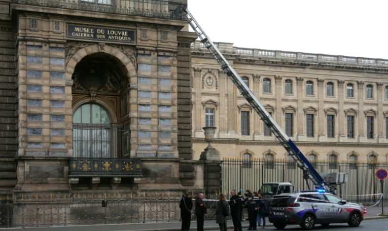 Des policiers français se tiennent à côté du monte-charge utilisé par des cambrioleurs pour pénétrer dans le musée du Louvre, sur le quai François Mitterrand, à Paris, le 19 octobre 2025 ( AFP / Dimitar DILKOFF )