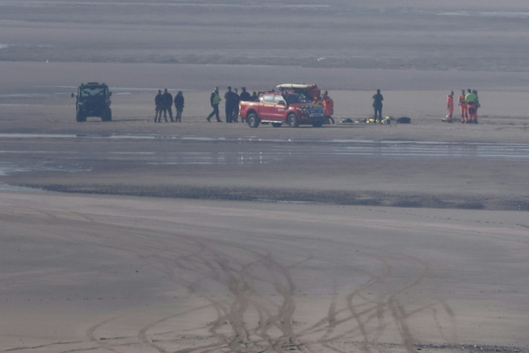 Des véhicules de secours et des unités médicales sur la plage pour soigner des migrants après qu'une tentative de traversée illégale de la Manche a tourné au drame, le 9 avril 2026 à Equihen-Plage, dans le Pas-de-Calais ( AFP / Sameer AL-DOUMY )