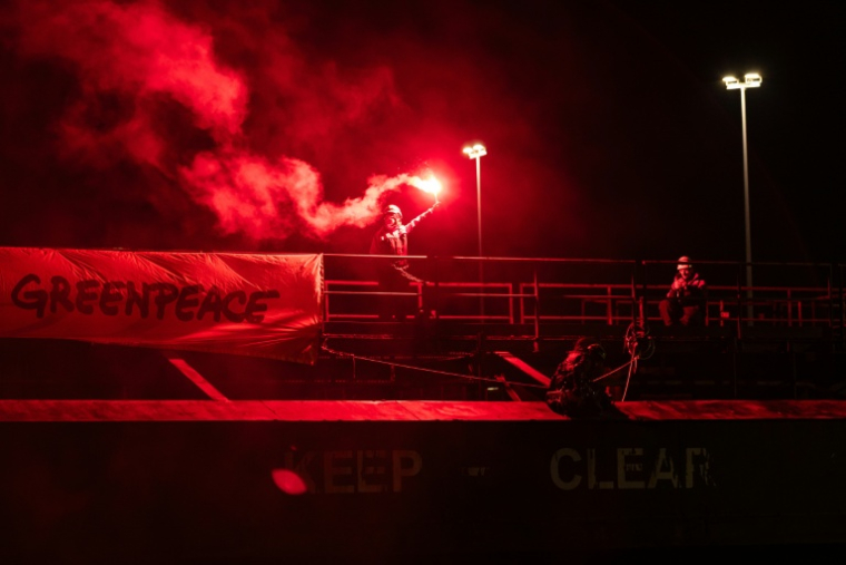 Un militant de Greenpeace lors d'une action pour dénoncer le commerce d'uranium entre la Russie et la France le 2 mars 2026 dans le port de Dunkerque ( AFP / Sameer Al-DOUMY )