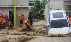 Des sauveteurs tentent d'évacuer des habitants piégés dans leur maison à Padang, dans la province indonésienne de Sumatra Ouest, le 27 novembre 2025 ( AFP / REZAN SOLEH )