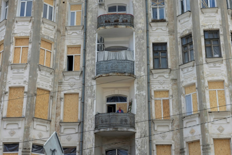 Un immeuble résidentiel endommagé par les frappes russes et dont les fenêtres détruites ont été remplacées temporairement par des planches de bois, à Kiev en Ukraine le 26 mai 2026 ( AFP / Tetiana DZHAFAROVA )