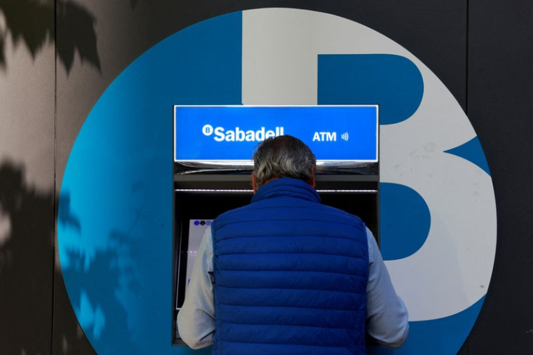 Un homme utilise un distributeur dans une agence de la banque espagnole Sabadell à Madrid