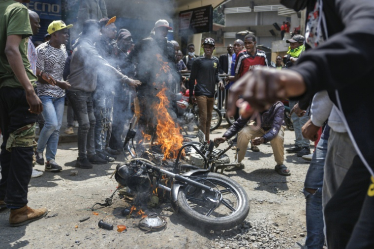 Des manifestants incendient une moto appartenant à des goons, des hommes de main présumés payés pour infiltrer les manifestations, le 23 juillet 2024 à Nairobi, au Kenya ( AFP / Tony KARUMBA )