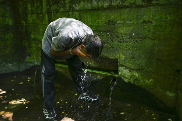 Un habitant se rafraîchit le visage à une source d'eau dans le village de Gorna Studena, lors d'une pénurie d'eau, le 2 juillet 2025 en Bulgarie ( AFP / Nikolay DOYCHINOV )