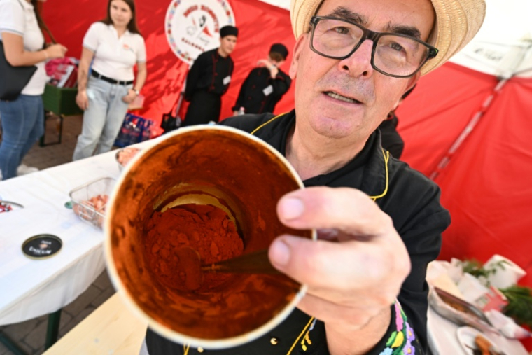 Un homme montre du paprika dans un récipient lors de la foire annuelle de Kalocsa, dans le sud de la Hongrie, le 19 septembre 2026 ( AFP / Attila KISBENEDEK )