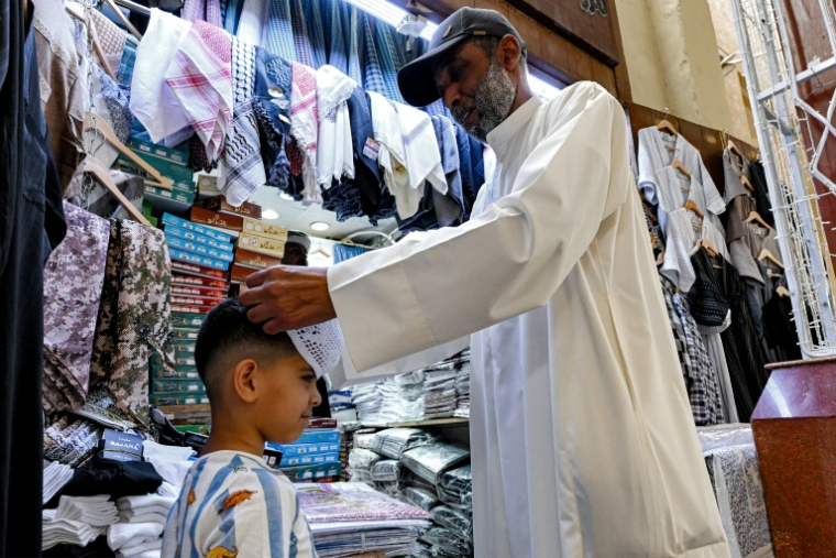 Un garçonnet se prépare pour la célébration de l'Aïd el-Fitr, marquant la fin du Ramadan, dans un marché traditionnel de la ville de Koweït, le 19 mars 2026. ( AFP / YASSER AL-ZAYYAT )