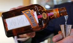 Un homme verse du Cointreau dans un verre