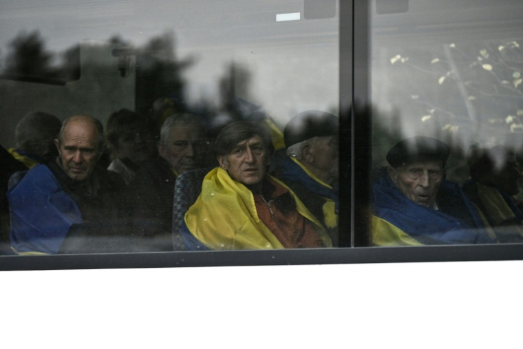 Des habitants d'Olechky, occupée par la Russie dans le sud de l'Ukraine, sont accueillis en Ukraine le 31 octobre 2026, après avoir été évacués via la Russie et le Bélarus grâce à une trêve annoncée par la Première dame américaine Melania Trump ( AFP / Genya SAVILOV )