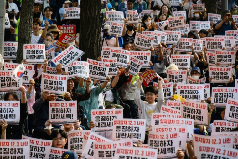 Des manifestants brandissent des pancartes "N'oublions pas l'insurrection du 3 décembre. Punissons les forces insurrectionnelles" lors d'un rassemblement à Seocho, dans le sud de Séoul, le 31 mai 2025, avant l'élection présidentielle du 3 juin ( AFP / ANTHONY WALLACE )