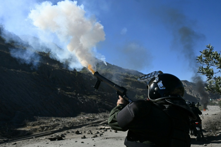 Un policier tire des gaz lacrymogènes vers des manifestants bloquant une route à Lipari, près de La Paz, le 16 mai 2026 ( AFP / AIZAR RALDES )
