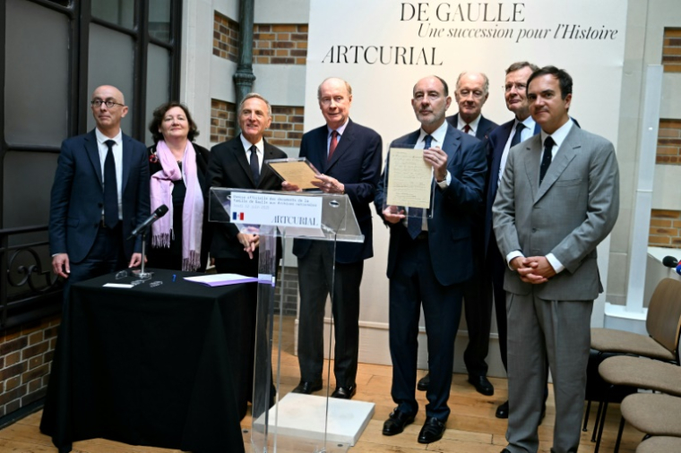Les petits-fils de Charles de Gaulle (à partir de la 4e g) Charles, Pierre, Yves et Jean de Gaulle, le commissaire-priseur Stéphane Aubert (d), le directeur du Service interministériel des archives (SIAF) Bruno Ricard (g) et la directrice des Archives nationales Marie-Françoise Limon-Bonnet (2e g) après la remise officielle du manuscrit de "l'Appel du 18 juin" aux Archives nationales, le 12 juin 2025 à Paris ( AFP / EMMA DA SILVA )