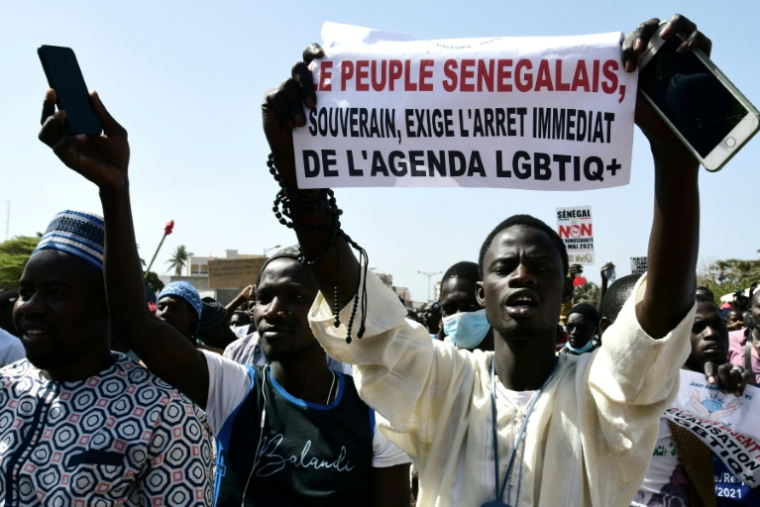 (ARCHIVES) Un manifestant brandit une banderole lors d'une manifestation réclamant la criminalisation de l'homosexualité au Sénégal, à Dakar, le 23 mai 2021 ( AFP / Seyllou )
