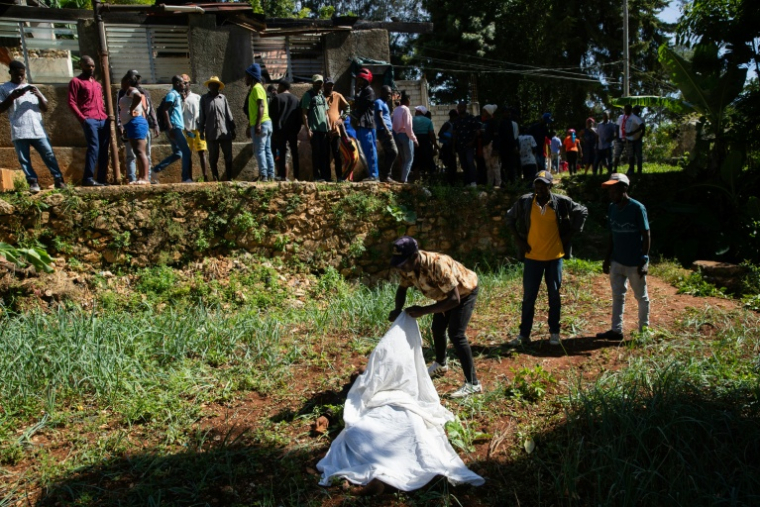 Un habitant regarde le corps d'une victime après des violences de gangs armés à Kenscoff, près de Port-au-Prince, le 24 août 2026 en Haïti ( AFP / Clarens SIFFROY )