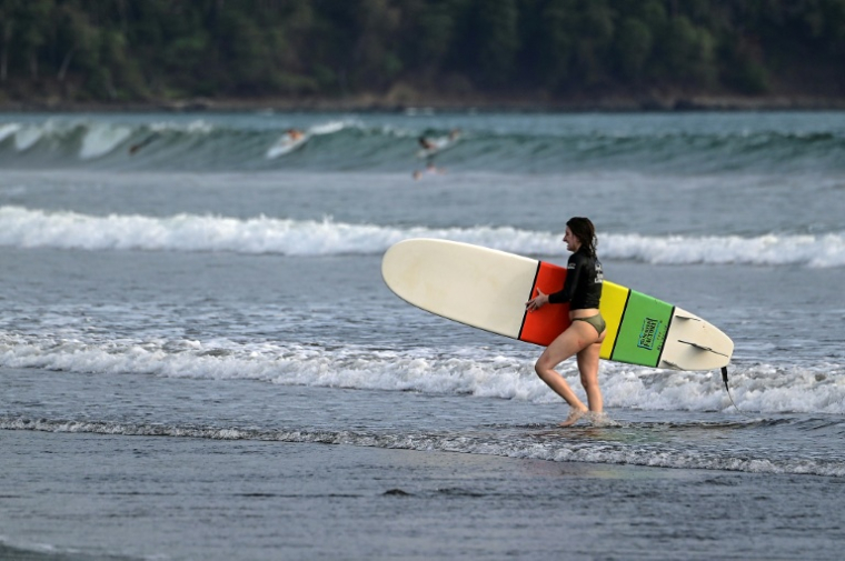 Une surfeuse sur une plage de Jaco, au Costa rica, le 30 mars 2022 ( AFP / Luis ACOSTA )
