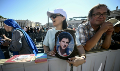Un fidèle tient un portrait du bienheureux italien Carlo Acutis à la veille de sa canonisation, lors d'une audience jubilaire sur la place Saint-Pierre au Vatican le 6 septembre 2025 ( AFP / Filippo MONTEFORTE )