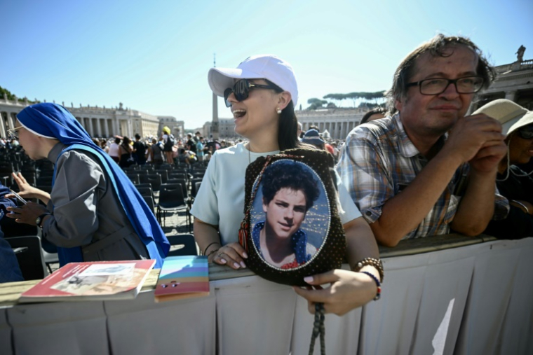 Un fidèle tient un portrait du bienheureux italien Carlo Acutis à la veille de sa canonisation, lors d'une audience jubilaire sur la place Saint-Pierre au Vatican le 6 septembre 2025 ( AFP / Filippo MONTEFORTE )