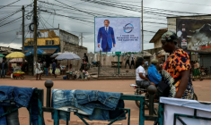 Des piétons passent devant un panneau publicitaire représentant le président camerounais Paul Biya, dans une rue de Yaoundé, le 28 octobre 2025, au lendemain de l'annonce des résultats de l'élection présidentielle au Cameroun.  ( AFP / - )