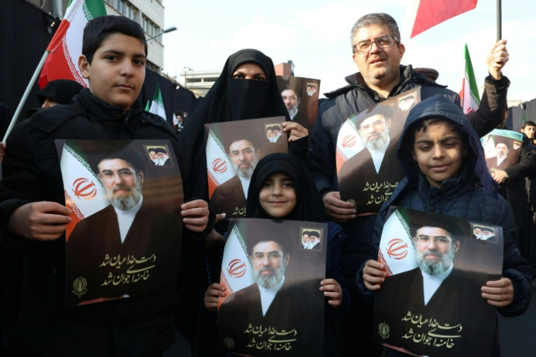 Des manifestants tiennent des portraits du nouveau guide suprême l'ayatollah Mojtaba Khamenei à Téhéran, le 9 mars. ( AFP / STR )
