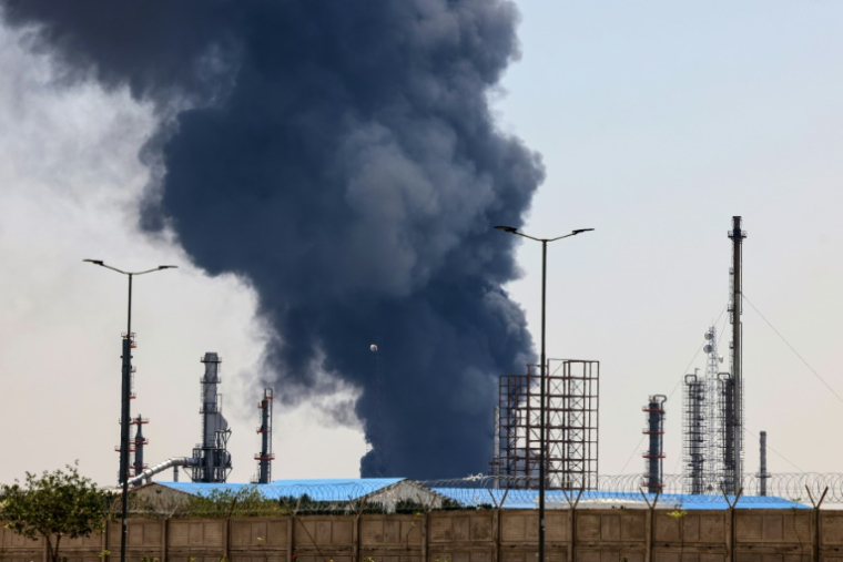Un panache de fumée au-dessus d'une raffinerie de pétrole dans le sud de Téhéran, après une frappe israélienne nocturne, le 15 juin 2025 en Iran ( AFP / ATTA KENARE )
