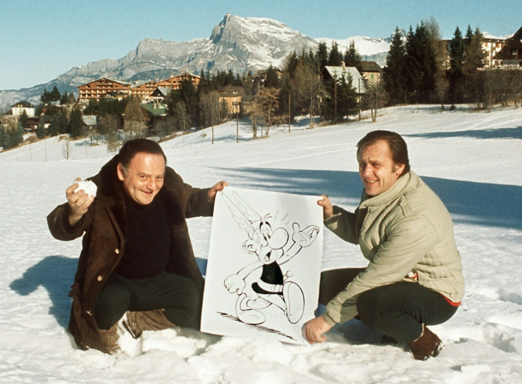 Les dessinateurs René Goscinny, à gauche, et Albert Uderzo à sa droite, posent avec une affichette d'Astérix le Gaulois à Megève, en Suisse, en 1971 ( AFP / - )