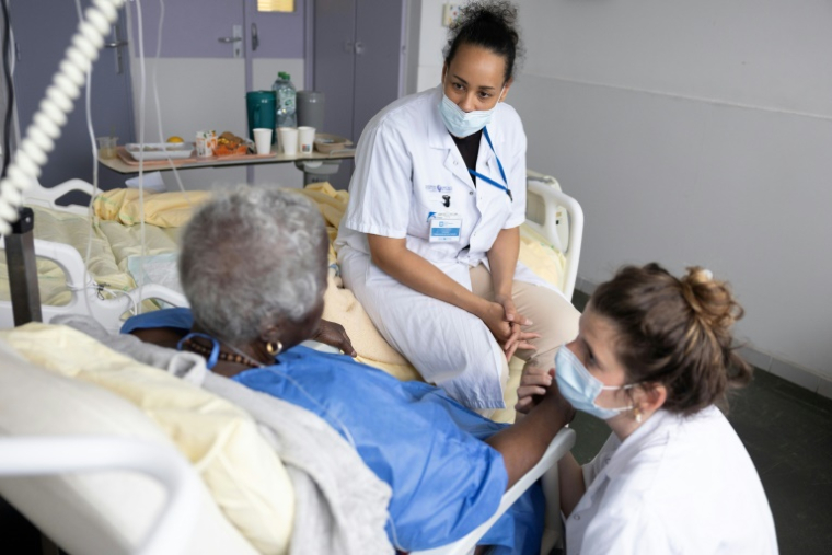 Une infirmière et une thérapeute au chevet d'une patiente en soins palliatifs à l'hôpital AP-HP Antoine-Béclère à Clamart, dans les Hauts-de-Seine, le 27 mai 2025 ( AFP / Thomas SAMSON )
