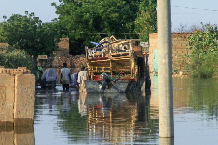 Des habitants transportent leurs effets personnels lors d'inondations dans le village de Wad Ramli au nord de Khartoum au Soudan, le 1er octobre 2025 ( AFP / Ebrahim Hamid )