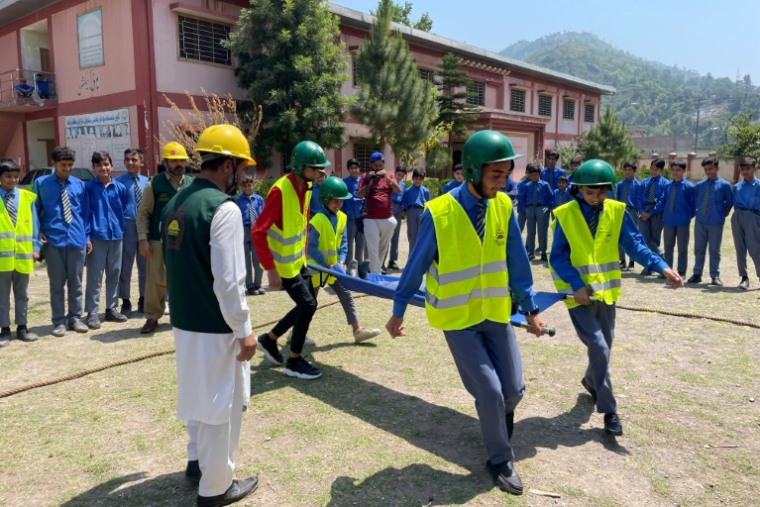 Des formateurs de la Défense civile donnent un cours de premiers secours à des écoliers dans une école à Muzaffarabad, au Cachemire pakistanais, où l'on craint un retour des hostilités avec l'Inde, le 30 avril 2025 ( AFP / Sajjad QAYYUM )