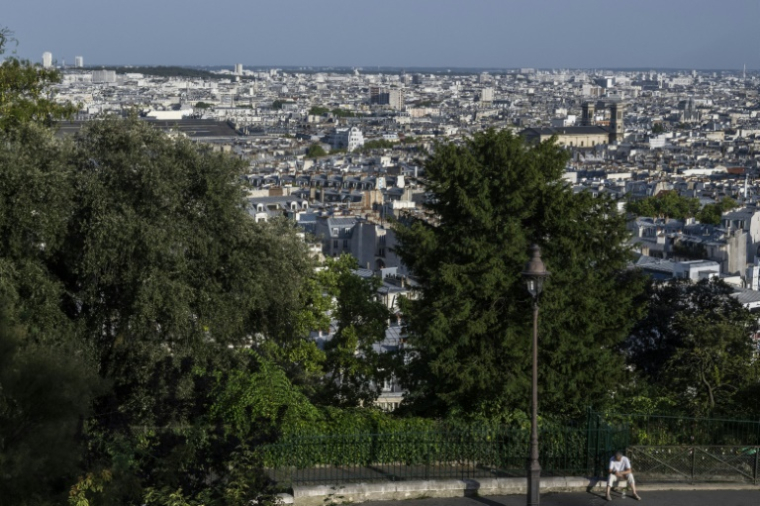 Un homme est assis sur un trottoir de la Butte Montmartre, à Paris, le 12 août 2025, en pleine canicule ( AFP / Martin LELIEVRE )