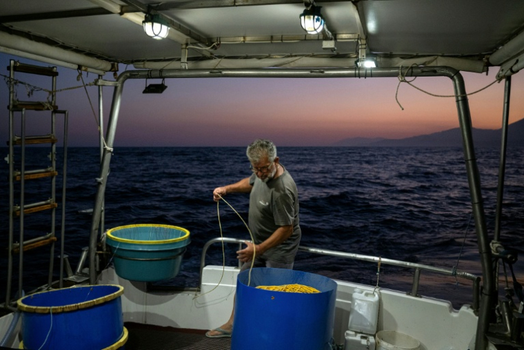 Le pêcheur grec Michalis Zevelekakis sur son bateau au large du port de Ierapetra, en Crète, le 3 juin 2026 ( AFP / Angelos TZORTZINIS )