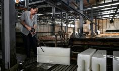 Un ouvrier transporte des blocs de glace vers un camion réfrigéré à l'usine de production de glace Feichao à Hangzhou, dans la province orientale du Zhejiang,  le 9 juillet 2025 en Chine ( AFP / Hector RETAMAL )