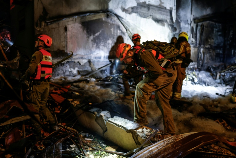 Des pompiers et des secouristes sur le site d'une frappe à Nahariya, dans le nord d'Israël, le 16 mars 2026 ( AFP / Odd ANDERSEN )