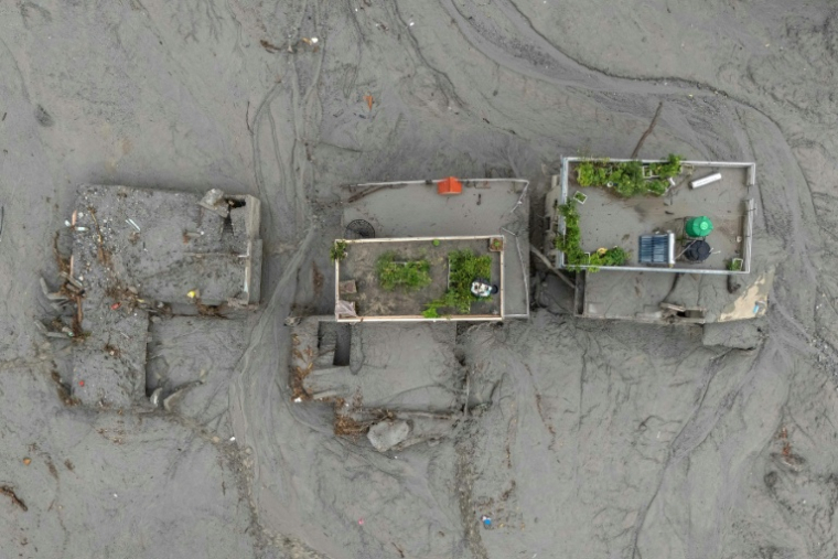 Vue aérienne de maisons recouvertes de boue après la crue destructrice qui a fait plus de 600 morts à la frontière entre le Népal et la Chine, le 29 août 2026 à Devighat, dans le district népalais de Nuwakot ( AFP / Manan VATSYAYANA )