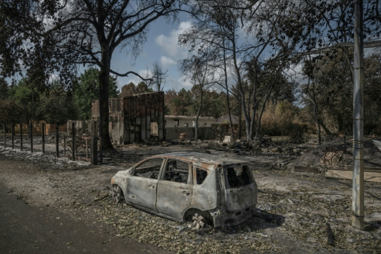 Une maison et une voiture détruites dans l'incendie qui a ravagé la commune de Le Porge, en Gironde, le 31 juillet 2026 ( AFP / Ed JONES )