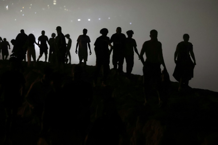 Des migrants marchent en direction de la région de Fnideq, dans le nord du Maroc, après avoir quitté l’enclave nord-africaine espagnole de Ceuta, près de la ville de Fnideq, à la frontière maroco-espagnole, à la suite d’une tentative de franchissement au poste-frontière de Bab Sebta, à la frontière maroco-espagnole, le 1er août 2026 ( AFP / Abdel Majid BZIOUAT )