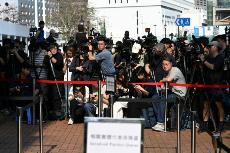 Des journalistes attendent, le 19 mars 2026 à Hong Kong,  l'arrivée des participants aux audiences publiques du comité d'enquête sur l'incendie qui a ravagé fin 2025 un complexe résidentiel ( AFP / Peter PARKS )