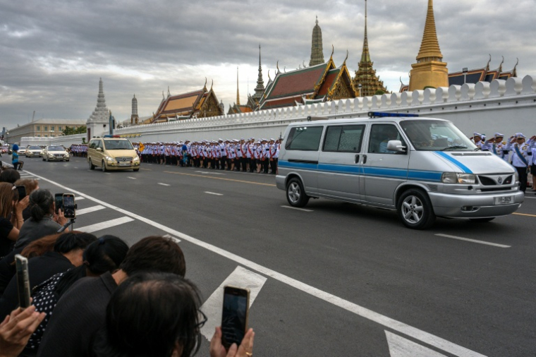 Des Thaïlandais assistent au passage du cortège funèbre amenant la dépouille de la reine mère Sirikit au Palais royal de Bankok, le 26 octobre 2025 ( AFP / Chanakarn Laosarakham )