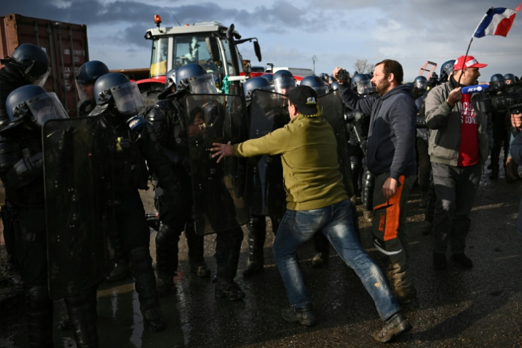 Des agriculteurs font face aux gendarmes, intervenus pour faire lever le blocage d'un dépôt de carburant de Bassens, près de Bordeaux, le 10 janvier 2026 ( AFP / Christophe ARCHAMBAULT )