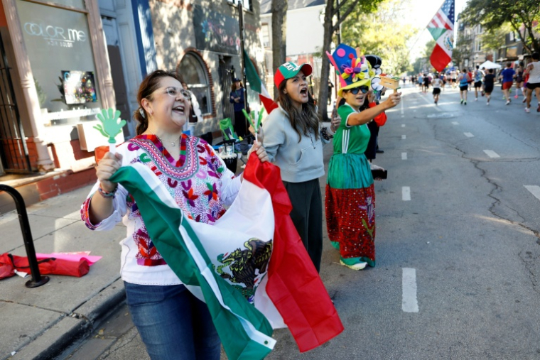 Une femme tient un drapeau mexicain dans le quartier de Pilsen lors du marathon de Chicago, le 12 octobre 2025 dans l'Illinois ( AFP / OCTAVIO JONES )