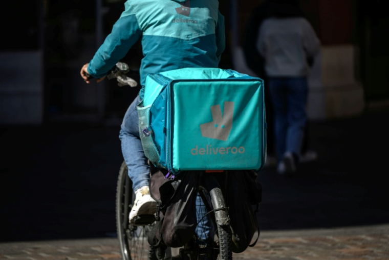 Un livreur Deliveroo à vélo dans une rue de Toulouse, le 18 mars 2025 ( AFP / Ed JONES )