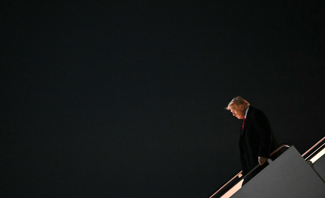 Le président américain Donald Trump descend de l'avion présidentiel Air Force One à son arrivée à la base militaire de Joint Base Andrews, dans le Maryland, le 13 avril 2025. Il revient à Washington après avoir passé le week-end en Floride. (Photo : Mandel NGAN / AFP)