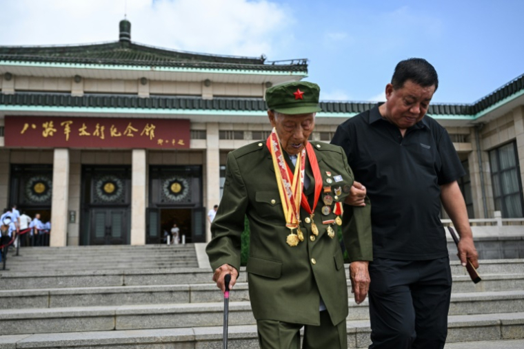 Li Jinshui (g), ancien combattant communiste de la Seconde Guerre sino-japonaise, devant le mémorial Taihang de l'armée de la huitième route à Wuxiang, dans la province du Shanxi, le 23 juillet 2025 au nord de la Chine ( AFP / HECTOR RETAMAL )