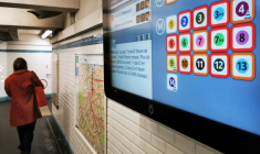 Une femme passe devant un écran d'information affichant la liste des lignes de métro dont le service est interrompu à Paris