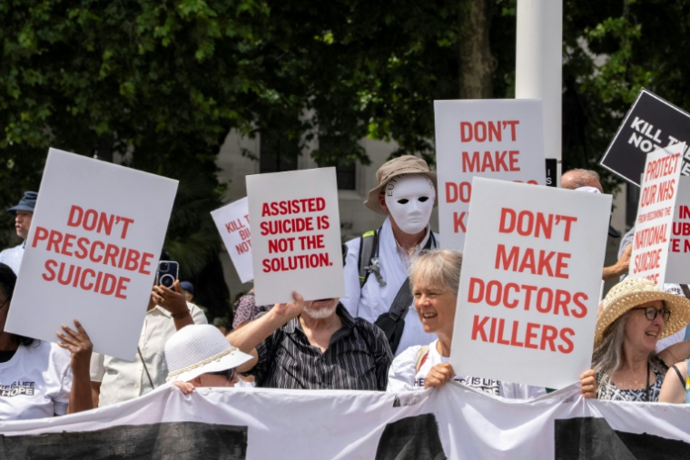 Des manifestants opposés à une modification de la loi sur l'aide médicale à mourir rassemblés devant le Palais de Westminster, le 20 juin 2025 à Londres, alors que les députés doivent voter sur l'opportunité d'autoriser l'aide à mourir pour certains malades en phase terminale ( AFP / CARLOS JASSO )